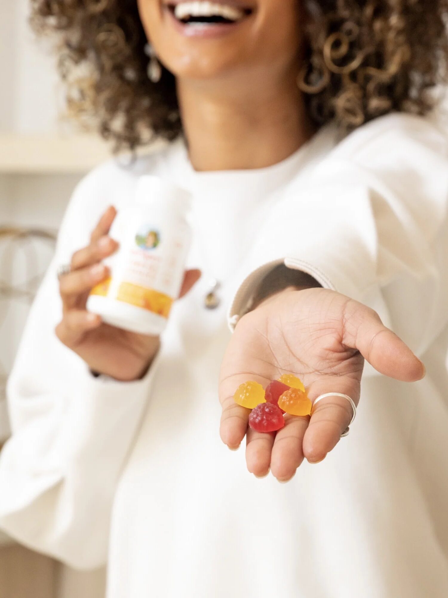 A hand holding out Multivitamin gummies from MaryRuth Organics. 