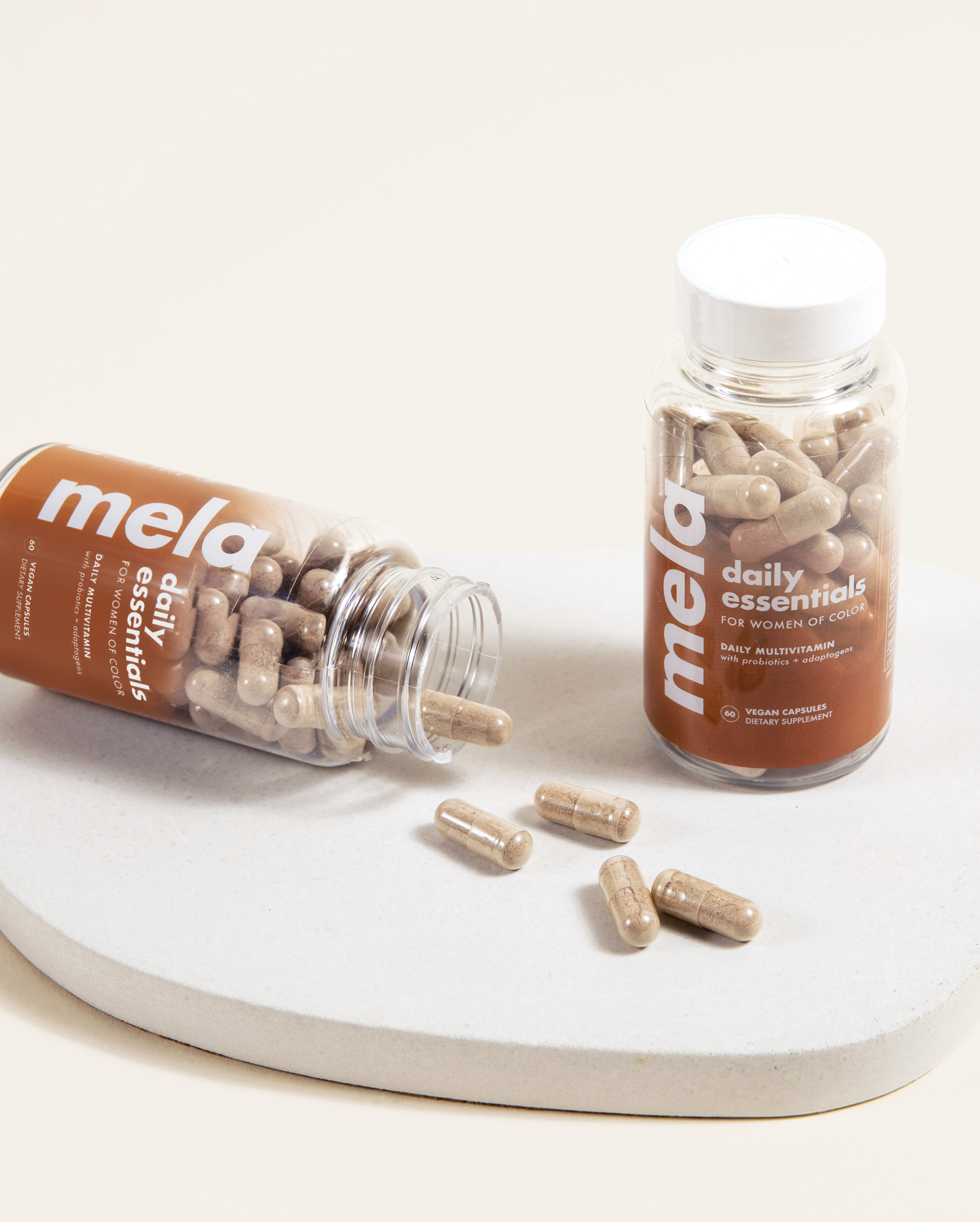Two bottles of Mela Daily Essentials for Women of Color. 