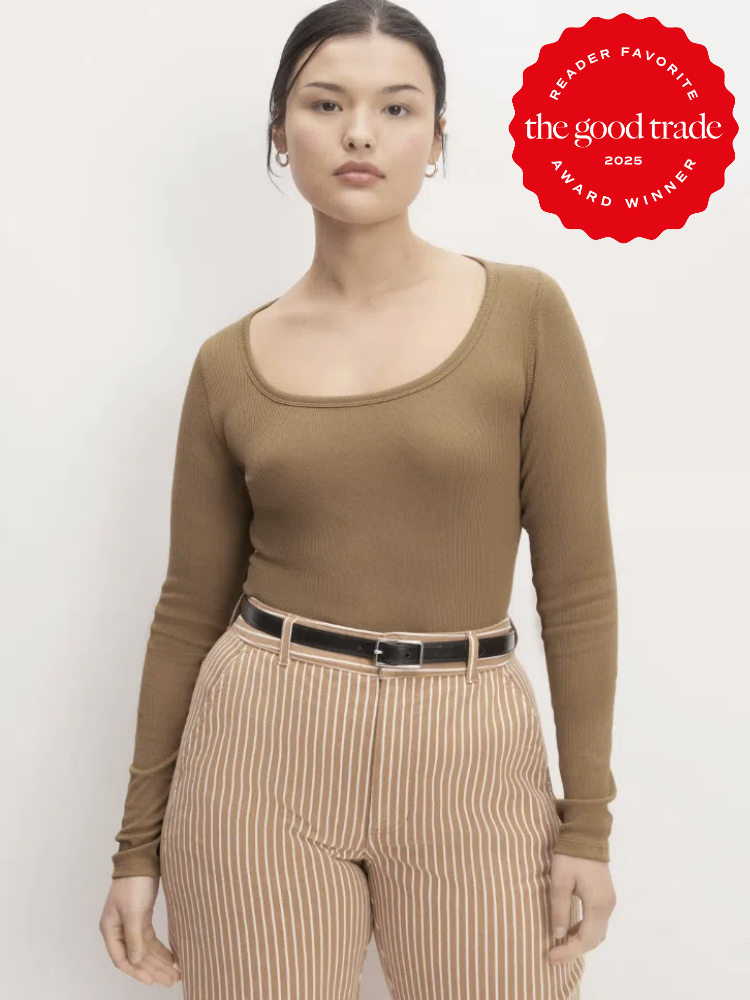 Person wearing a brown long-sleeve top and striped pants against a plain background. A red badge reads "READER FAVORITE FashionGroomSpot 2025 AWARD WINNER.