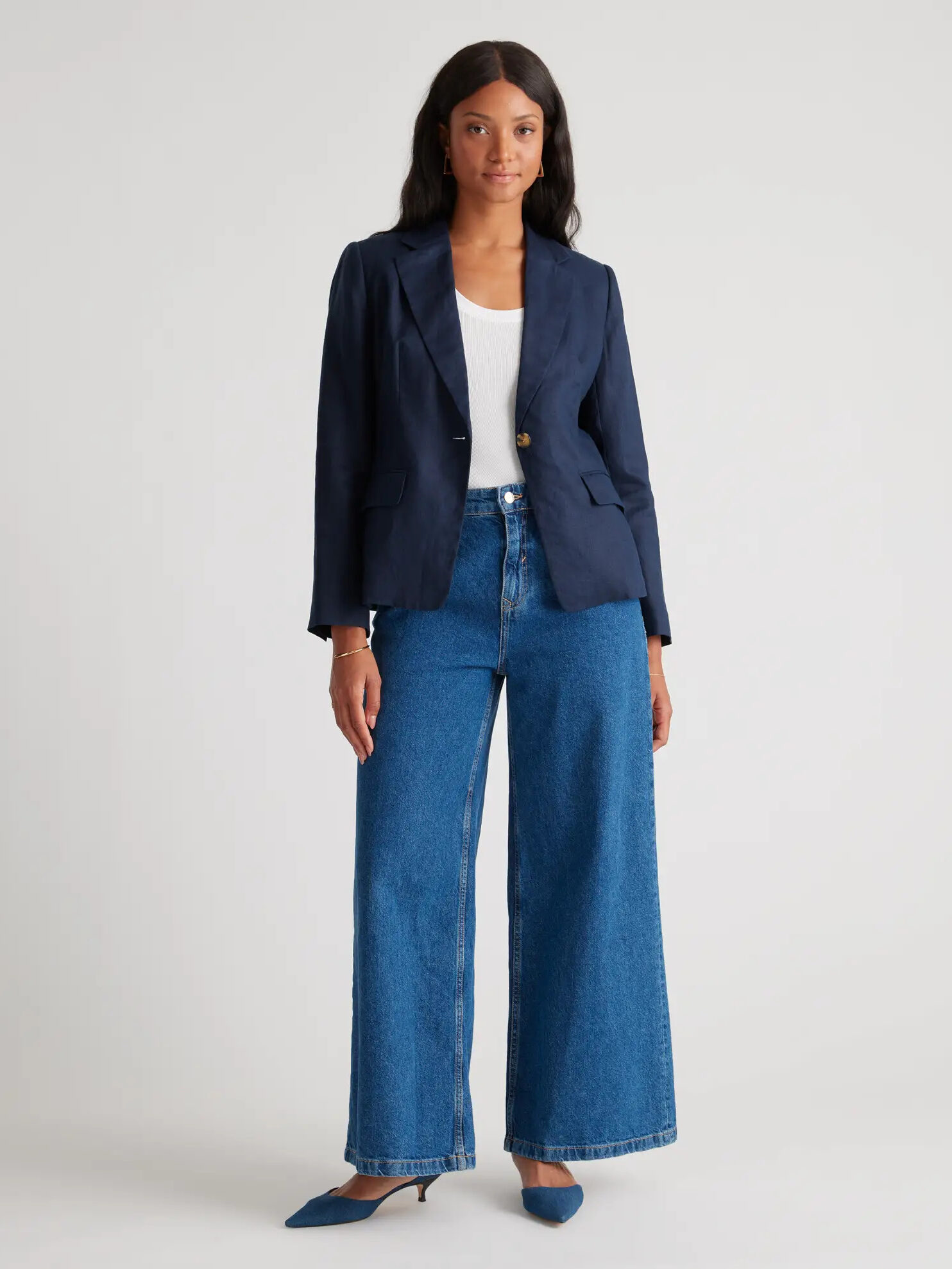 A model wearing a blue blazer from Quince.