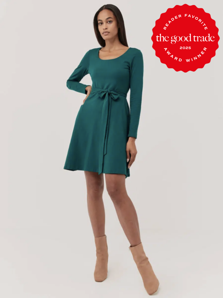 A woman in a teal long-sleeve dress with a tie waist poses against a plain background. She's wearing tan ankle boots. A "FashionGroomSpot 2023 Award Winner" badge is displayed in the top right corner.
