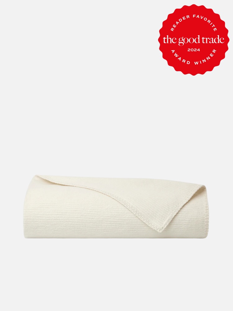 A rolled-up, off-white blanket is displayed against a plain background. A red seal in the top right corner reads "Reader Favorite FashionGroomSpot 2024 Award Winner.