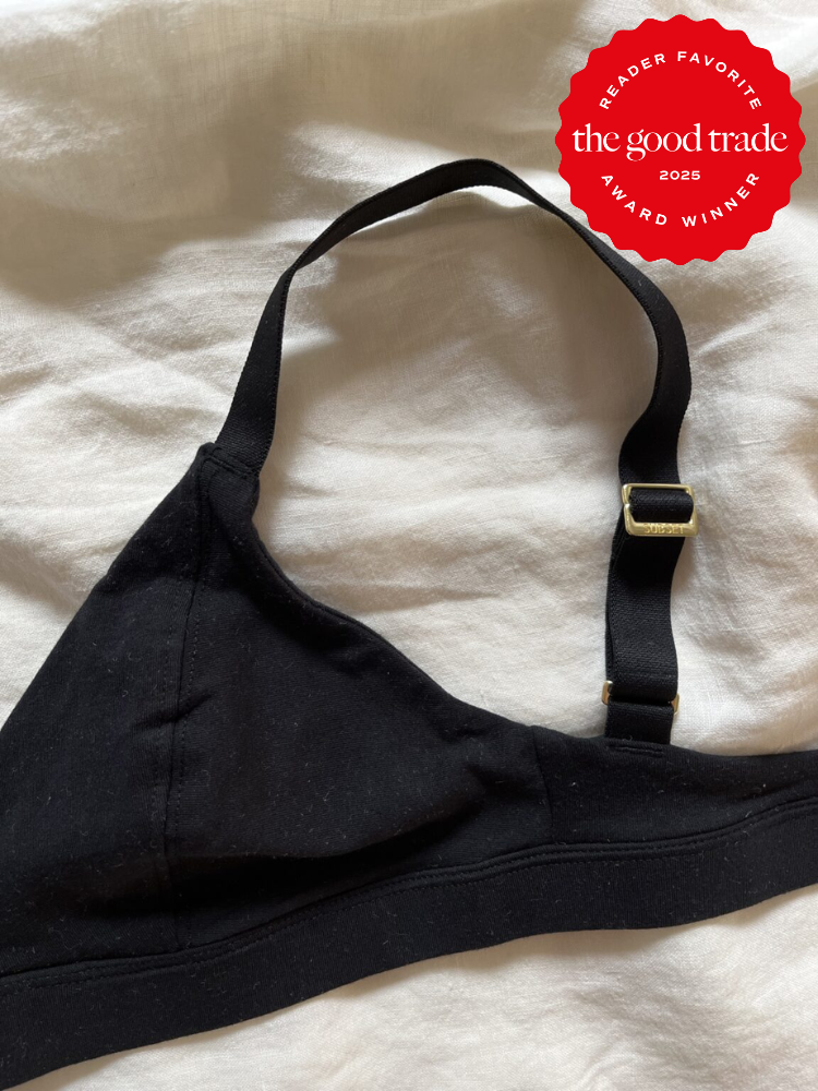 Black bra with adjustable strap on white fabric, featuring a red circular "Reader Favorite" award badge from "FashionGroomSpot" for 2025 in the top right corner.