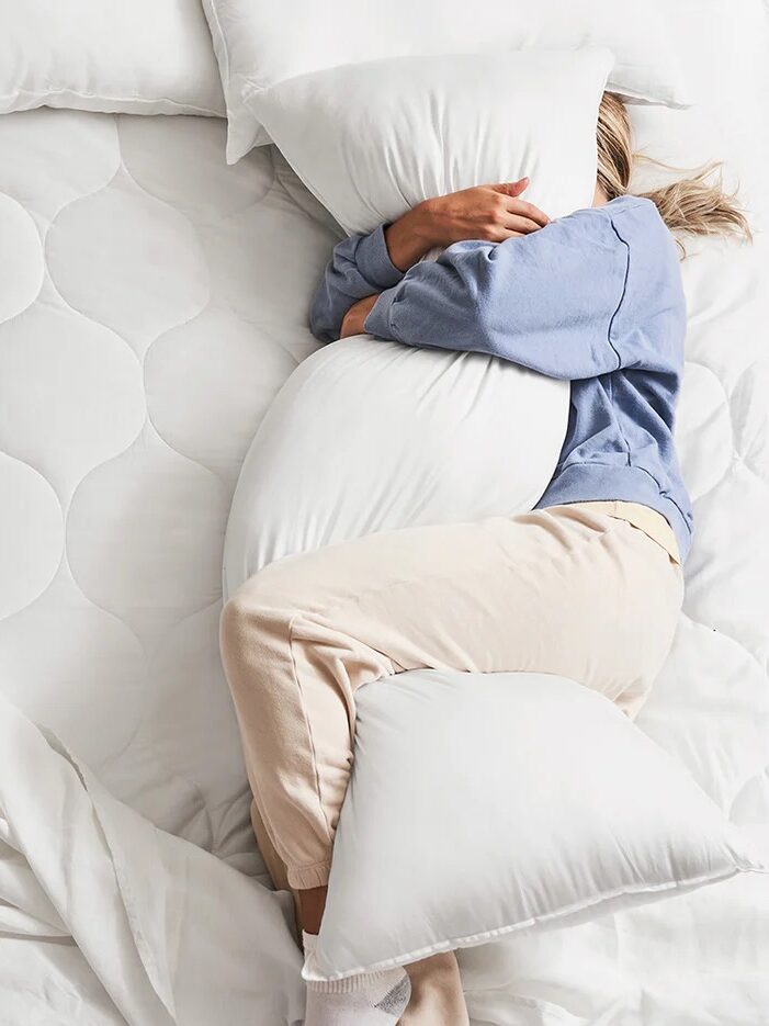 A model snuggling with a Buffy pillow.