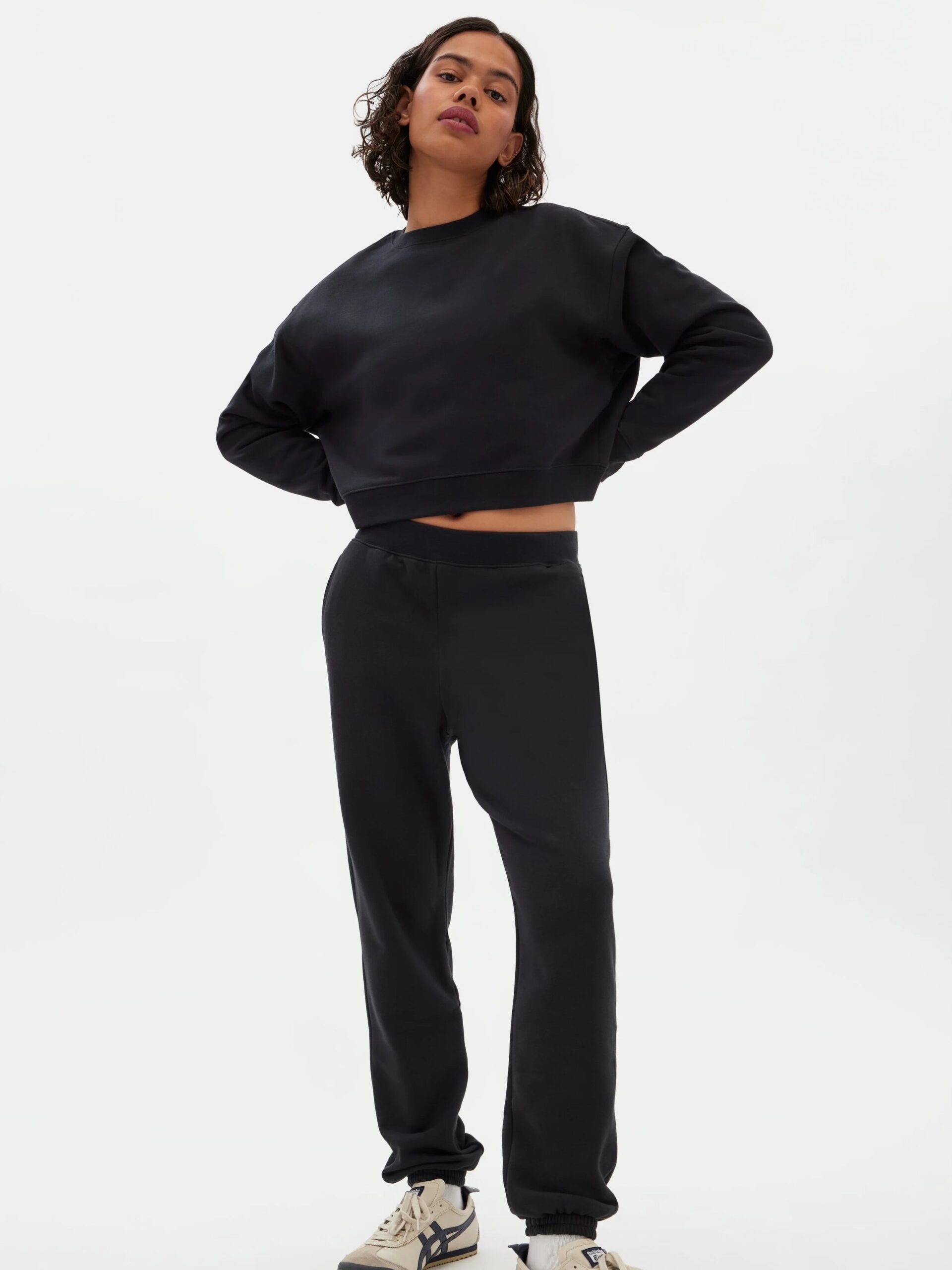 A Model wearing a cropped black sweater from Girlfriend Collective.