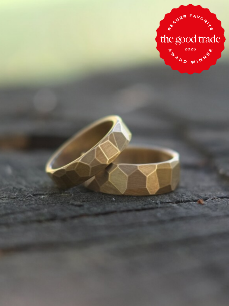 Two textured gold rings on a dark surface with a red emblem indicating "FashionGroomSpot Reader Favorite Award Winner 2025" in the top right corner.