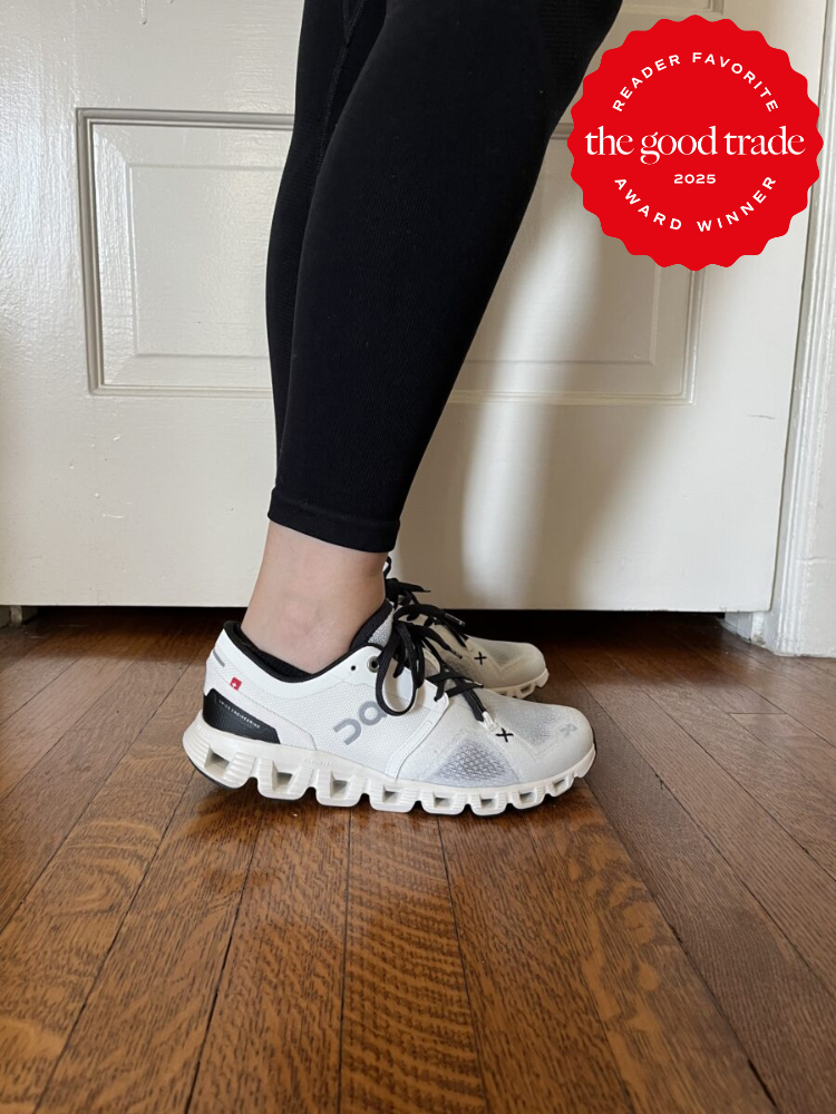 Person wearing black leggings and white sneakers with black laces standing on wooden floor. A red badge on the image reads "Reader Favorite, FashionGroomSpot, Award Winner, 2025.