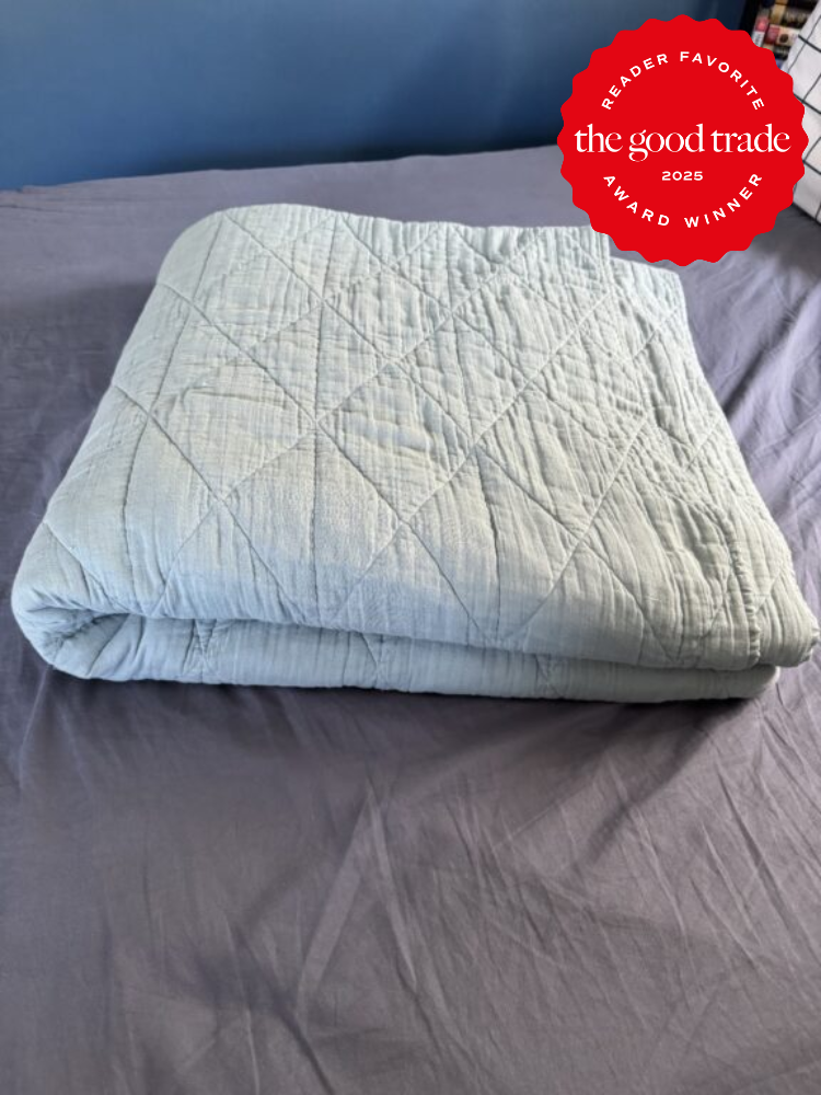 Folded quilt on a bed with an award badge in the corner reading "Reader Favorite, FashionGroomSpot, 2025 Award Winner.