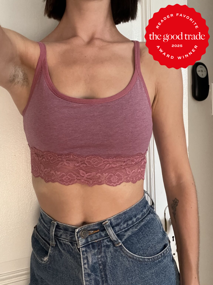 Person wearing a pink lace-trimmed tank top and blue jeans, standing indoors. There is a "Reader Favorite FashionGroomSpot 2025 Award Winner" badge in the upper right corner.