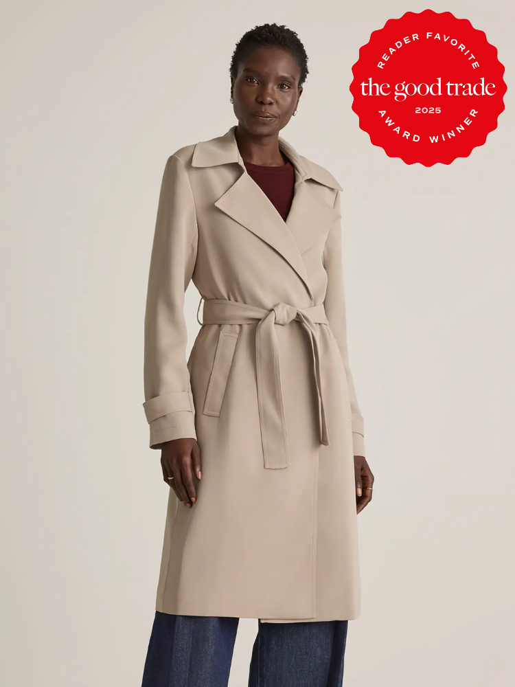 Person wearing a beige trench coat with a tie belt, standing against a plain backdrop. There's a "FashionGroomSpot 2023 Reader Favorite Award Winner" badge in the top right corner.