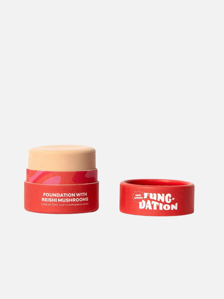Foundation stick with Reishi mushrooms in a red container, shown with its cap off beside it on a plain background.