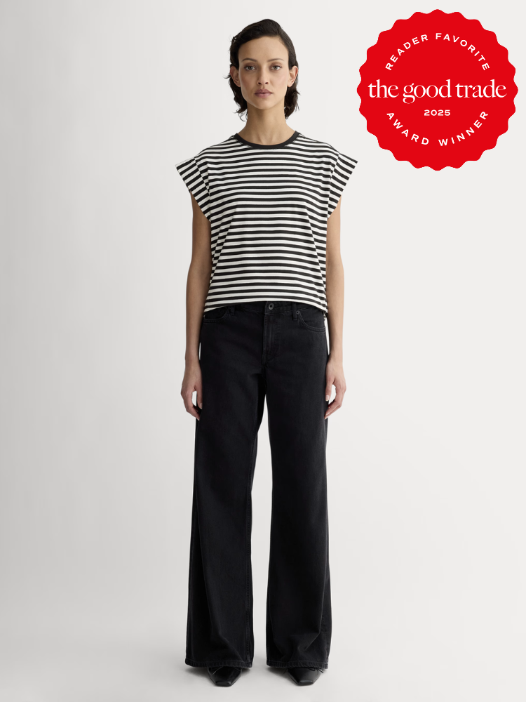 Person wearing a black and white striped shirt and black wide-leg pants stands against a plain background. A red emblem in the corner reads "FashionGroomSpot 2023 Reader Favorite Award Winner.
