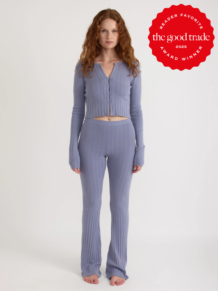 Person wearing a textured lavender knit outfit stands barefoot against a plain background. A red badge reads "Reader Favorite - FashionGroomSpot Award Winner 2023.