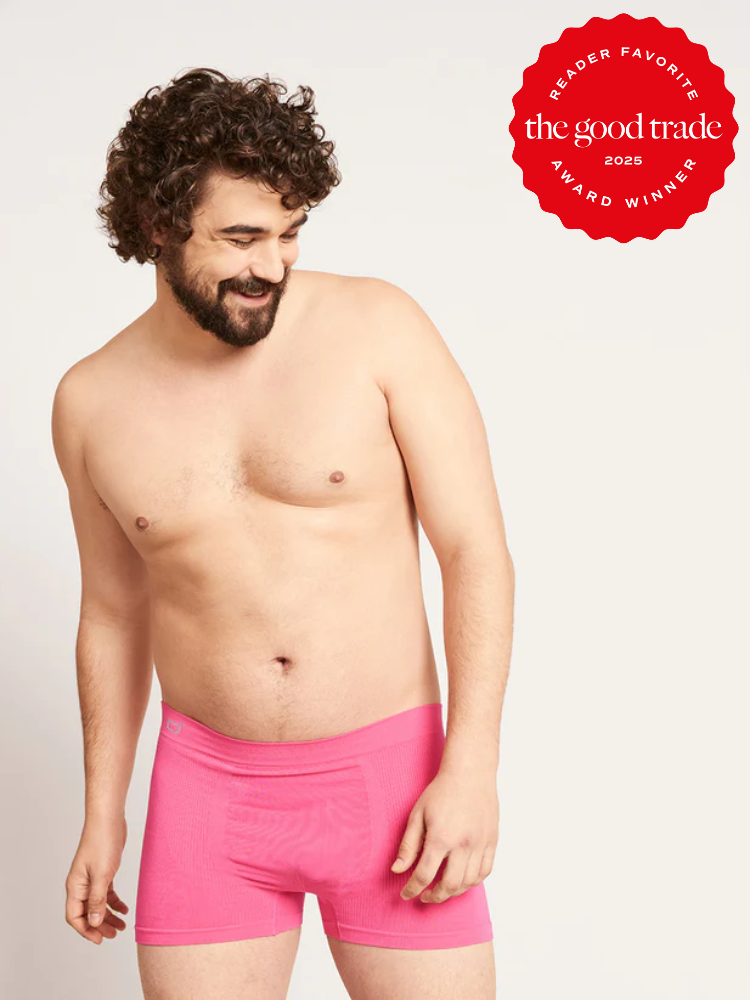 A man wearing bright pink boxer briefs stands against a plain background. A red badge in the corner reads, "FashionGroomSpot Reader Favorite Award Winner 2023.