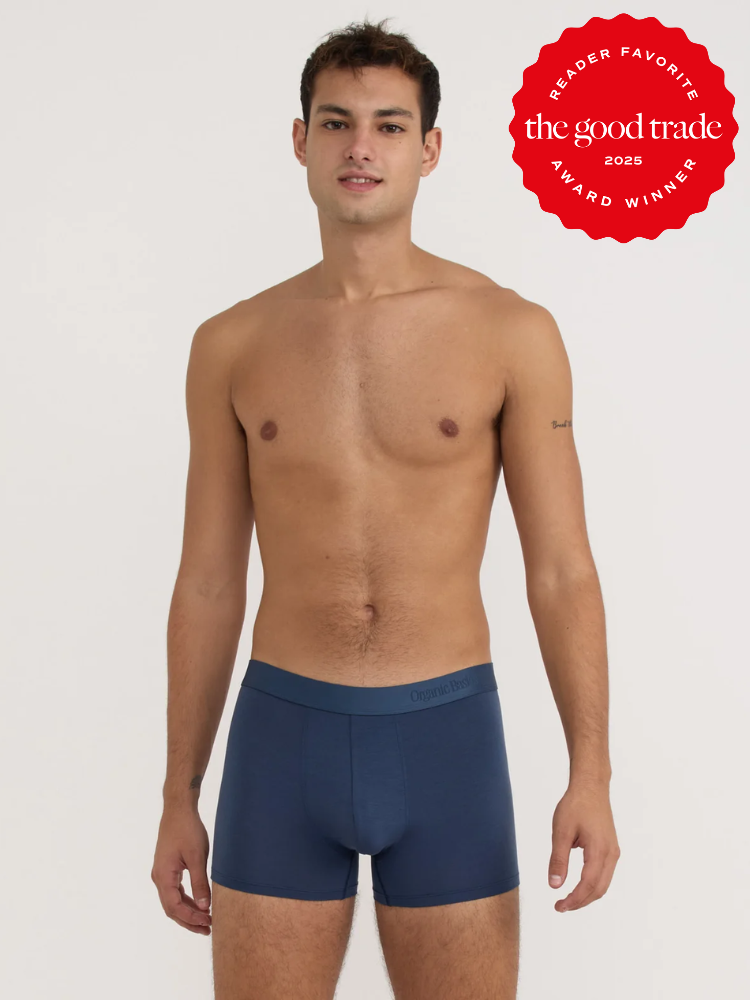 A man stands against a plain background wearing navy blue boxer briefs. A red badge in the top right corner reads "FashionGroomSpot reader favorite award winner 2025.
